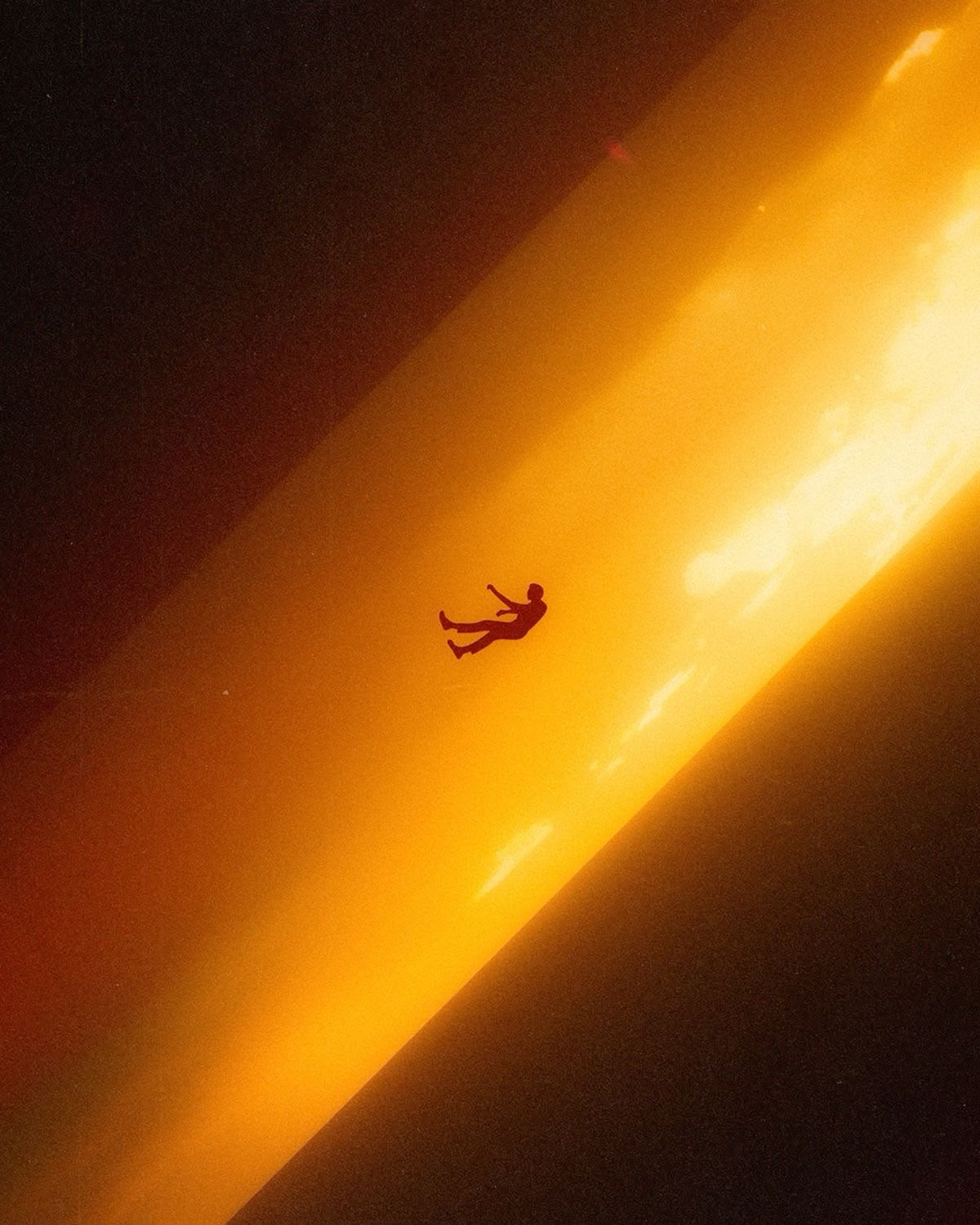 A figure suspended in a beam of golden light